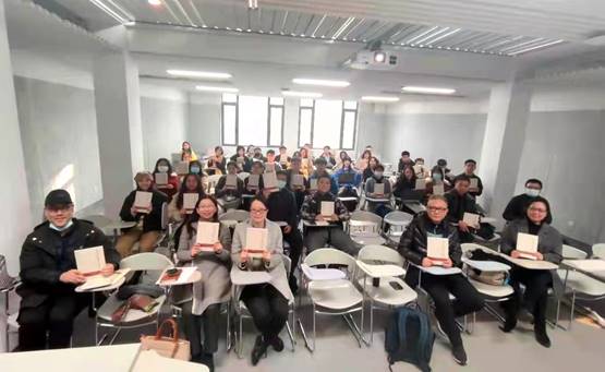 a group of people sitting in a room  description automatically generated with low confidence